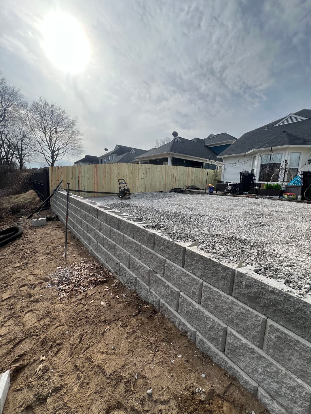 Retaining wall and Artificial Turf base preparation in Memphis, TN featuring properly compacted gravel foundation and structural block wall built to support a level, long-lasting Turf installation.